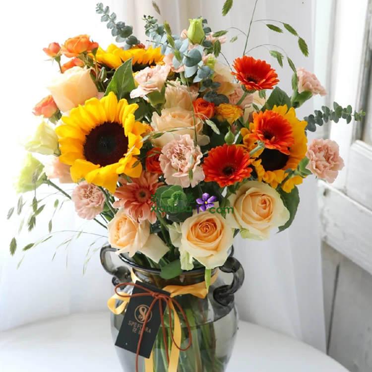 8枝香槟玫瑰,3枝向日葵,3枝橙色扶郎,3枝粉色扶郎,10枝粉色康乃馨,橙色多头玫,绿色洋桔梗,小盼草,尤加利叶搭配