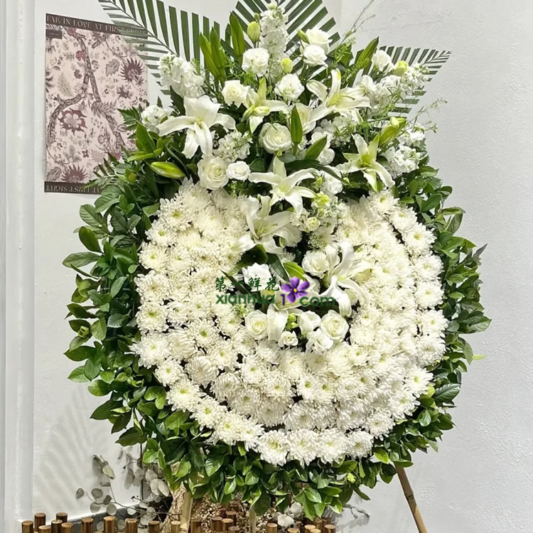 外层：白菊围成4圈；中间：白香水百合12朵、白玫瑰6枝、白色紫罗兰6枝，白色洋桔梗搭配；散尾叶、栀子叶外围。